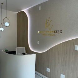 Balcão da recepção com o logotipo Kelly Carneiro iluminado